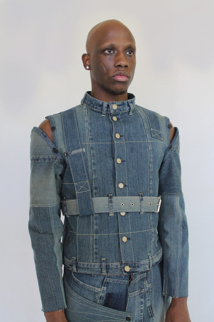 Reconstructed denim jacket, open shoulder, straps, sustainable fashion.