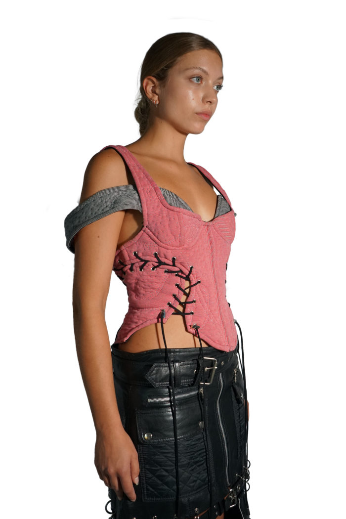 Salmon colored corset with black lacing and a grey drop shoulder